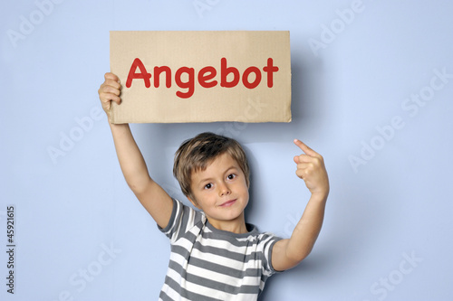 Photo: Kind macht mit einem Schild ein Angebot Kind macht mit einem Schild ein Angebot