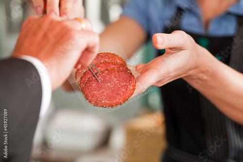 Photo: Butcher Showing Fresh Meat Steaks to Customer Butcher Showing Fresh Meat Steaks to Customer