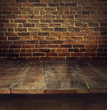 Foto: Old wooden table with brick background Old wooden table with brick background
