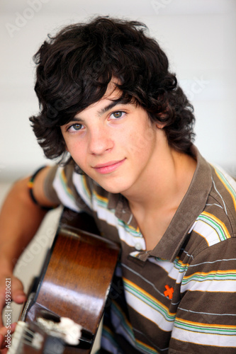 Photo: Young man playing a guitar Young man playing a guitar