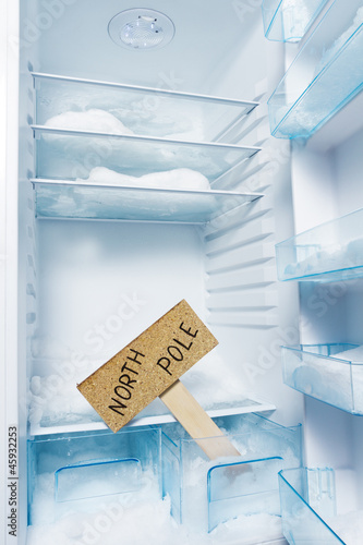 Photo: Fridge with frost and North Pole sign. Global warming Fridge with frost and North Pole sign. Global warming