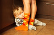 Boy hiding behind mother