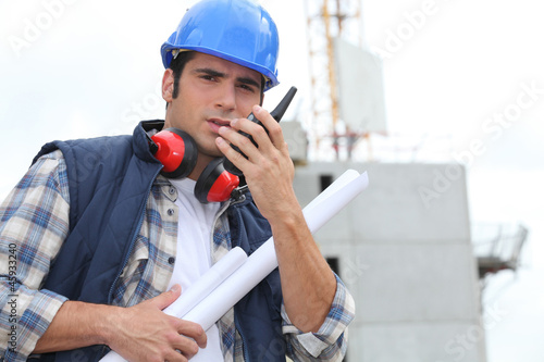 Photo: Tradesman speaking into a walkie talkie Tradesman speaking into a walkie talkie