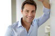 Portrait of handsome and happy guy leaning on wall