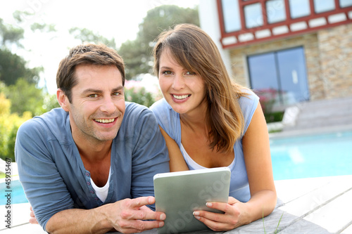 Photo: Couple websurfing on internet with tablet Couple websurfing on internet with tablet