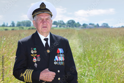Photo: Grandfather in form, cap, ordens, medals pose in field Grandfather in form, cap, ordens, medals pose in field