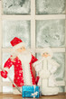 miniature toy Santa Claus, Snow Maiden near frost window