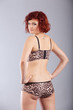 red haired woman in underwear with tatoo of dragonfly, bird pose
