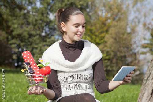 Photo: Cute girl thinks about online shop-concept Cute girl thinks about online shop-concept