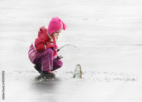 Photo: Little child fishing on a frozen lake in winter. Little child fishing on a frozen lake in winter.