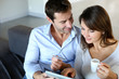 Mature couple at home using credit card to shop online