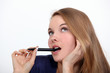 Woman holding pen to mouth