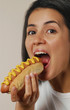 Mujer comiendo perro caliente,comida rápida.
