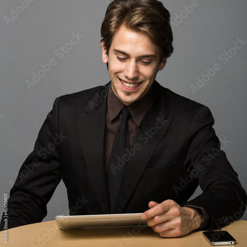 Photo: Mann liest am Tablettpc Mann liest am Tablettpc
