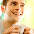 Young happy smiling man with cup of coffee
