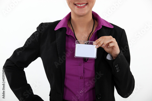 Photo: Woman displaying visitor badge Woman displaying visitor badge