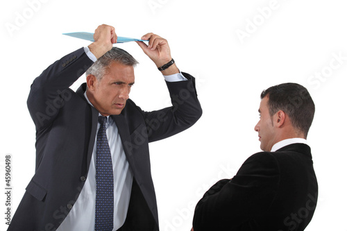 Photo: Angry boss about to hit employee with clip-board Angry boss about to hit employee with clip-board