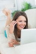 Smiling woman calling in front of her laptop