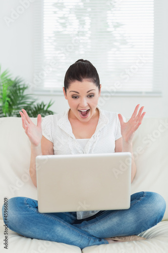 Photo: Lucky woman using a laptop on the couch Lucky woman using a laptop on the couch