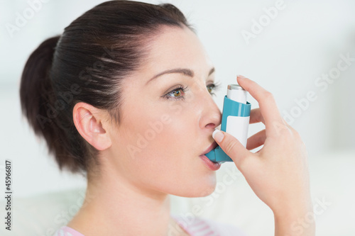 Photo: Woman using an asthma inhaler Woman using an asthma inhaler
