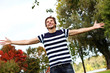 Happy and attractive young man at warm day in autumn park
