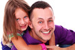 Cute little girl enjoying piggyback ride with her father over a