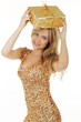 Hübsche blonde Frau im goldenen Kleid mit Geschenk