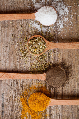Photo: curry, pepper, oregano and cooking salt in wooden spoons curry, pepper, oregano and cooking salt in wooden spoons