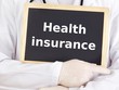 Doctor shows information on blackboard: health insurance