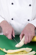 Foto: Köchin bereitet eine Banane mit einem Küchenmesser zu Köchin bereitet eine Banane mit einem Küchenmesser zu
