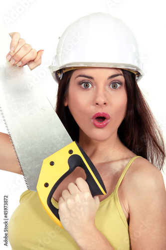 Photo: Surprised woman with a handsaw Surprised woman with a handsaw
