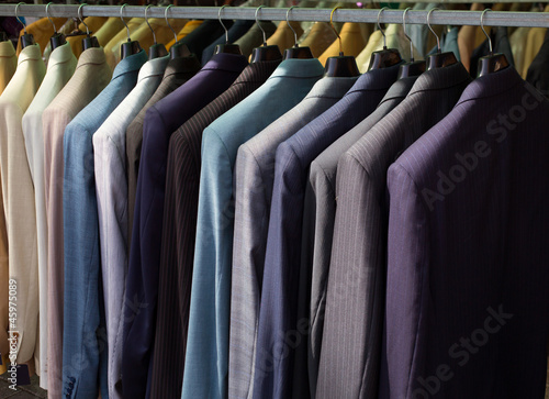 Photo: colorful male suits in row in a hanger colorful male suits in row in a hanger