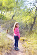 children girl walking in the pine forest with dog