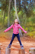 kid girl climbing tree trunks with open arms