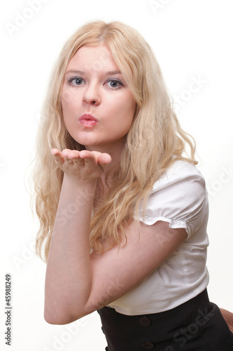 Photo: beautiful young woman blowing a kiss beautiful young woman blowing a kiss