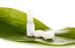 Eye drops and lenses on leaf isolated on white