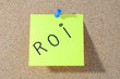 The word ROI Note paper with push pins on noticeboard