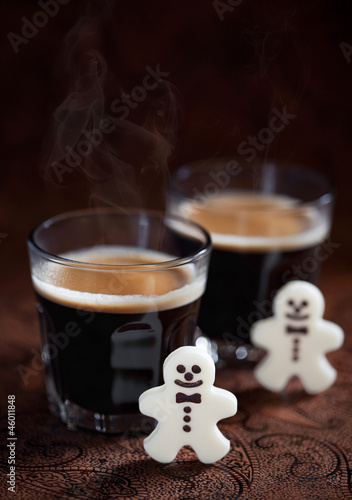 Photo: Hot espresso and white chocolate candy men, selective focus Hot espresso and white chocolate candy men, selective focus