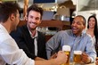 Young businessmen drinking beer at pub