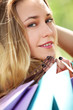 Beautiful smiling girl in park with shopping bags