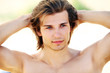 Portrait of young and handsome guy on the beach