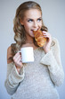 Cute girl holding white cup  and croissant while isolated
