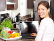 Woman using laptop computer in kitchen