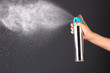 Sprayed air freshener in hand on grey background