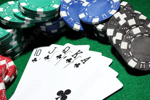 Photo: Cards and chips for poker on green table Cards and chips for poker on green table