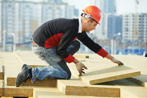 Photo: roofer worker installing roof insulation material roofer worker installing roof insulation material