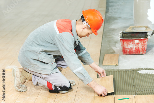 Photo: tiler at industrial floor tiling renovation work tiler at industrial floor tiling renovation work