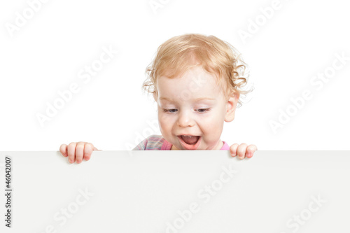 Photo: kid looking down behind white emty banner isolated kid looking down behind white emty banner isolated