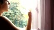 Young Adult Woman Finger Draws On Window