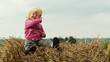 child is sitting on a haystack